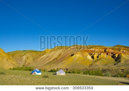 Yurta Is Set Against The Background Of Multi-colored Mountains