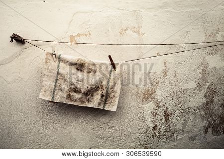 Rag Hung Out To Dry Outdoors. Home With Wire To Dry Under The Sun. Old Italian House With Grunge Wal