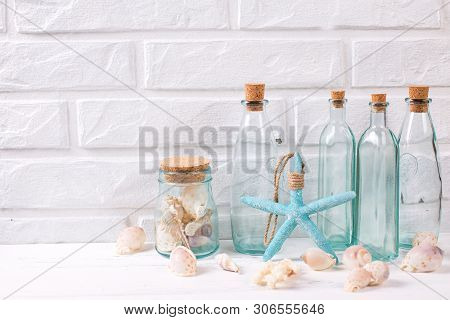 Summer Sea Living  Layout Near By White Brick Wall. Shells,  Starfish  And Blue Bottles With Shells.
