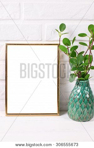 Empt Golden Frame Mockup  With Copy Space And Branch In Vase  Near By Brick White Wall. Portrait Ori