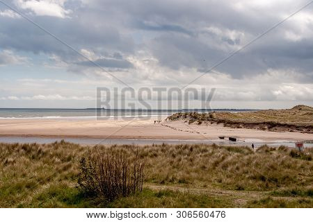 Alnmouth Beach, Northumberland, England. 11 May 2019. Alnmouth Beach With A Walkers With Coquet Isla