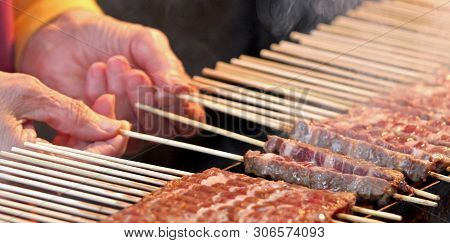 Hand Of Old Woman And Raw Meat Called Arrosticini In Italian Language