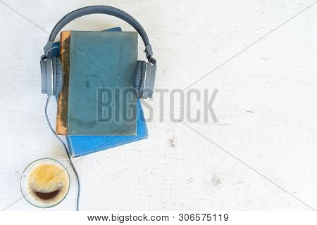 Audio Book Concept. Headphones With Books And Cup Of Coffee On Wooden Table. Top View With Copy Spac