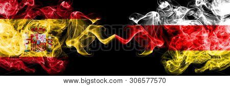 Spain Vs South Ossetia Smoky Mystic Flags Placed Side By Side. Thick Colored Silky Smokes Flag Of Sp