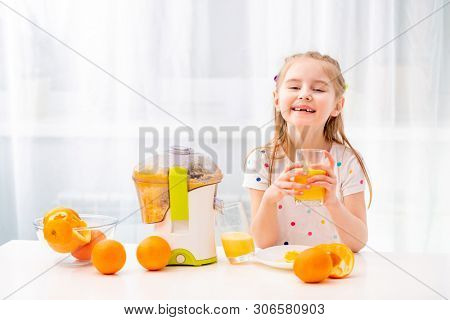 Braided girl enojoying morning glass of orange juice