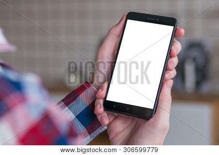 Mockup Image: Man Looking At Black Smartphone With White Blank Screen. Close Up View Of Man Hands Wi