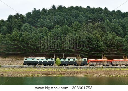North Korea, Pyongyang - April 30, 2019: Countryside. North Korea. Electric Locomotive Carries Cars 