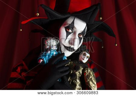 Pretty Jester Woman Holding Two Clown Dolls.