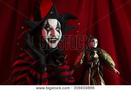 Cheerful Jester Woman Playing With Jester Doll.