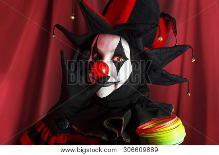Cute Cheerful Jester Woman With Red Clown Nose And Rainbow Spring Toy.