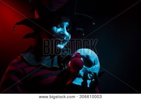 Creepy Jester Woman Holding A Human Skull With Red Clown Nose.