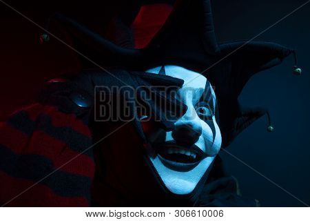 Scary Smiling Jester Woman Covering Her Face With Her Hand, Close-up.
