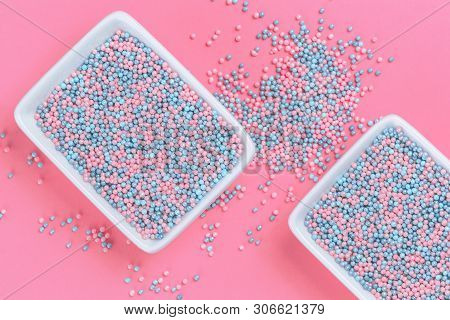 Colorful Nonpareils Cake Candy Sprinkles In Two White Rectangular Bowls And Spoon On Pink Background