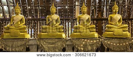 Row Of Four Golden Buddha Statues Sitting On Pillows In Seema Malaka Temple.