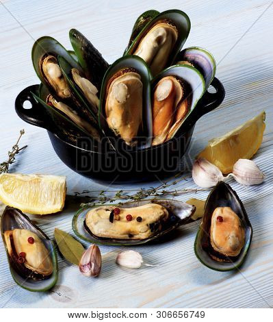 Boiled Green Mussels With Herbs, Garlic And Lemon In Blue Pannikin Closeup On Blue Wooden Background