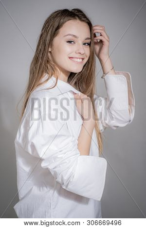 Pretty Smiling Joyfully Female With Fair Hair. Portrait Of Cheerful Beautiful Woman Over Grey Backgr
