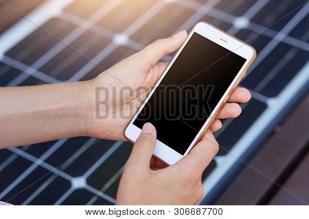Outdoor Photo Of Faceless Person Harging Mobile Phone Via Usb. Public Charging On Bench With Solar P