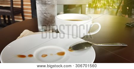 Coffee In Cup And Sprinkled With Drops On A White Plate. Creative Coffee Art Background
