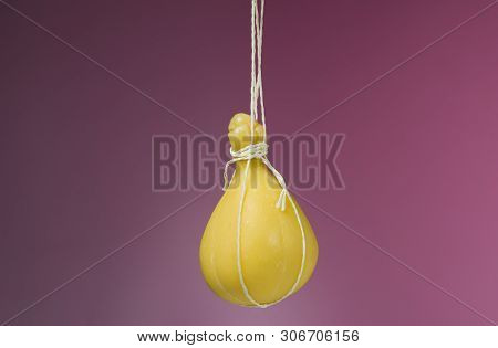 Typical Italian Cheese Caciocavallo Against On A On The Violet-purple Background.