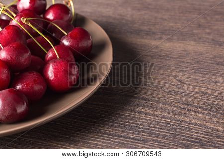 Fresh Cherries On A Brown Plate On A Wooden Table. Summer Food, Healthy Eating. Organic, Vegetarian,
