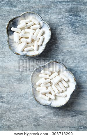 Theanine Capsules. Dietary Supplement.   Rustic Wooden Background. Top View. Copy Space.