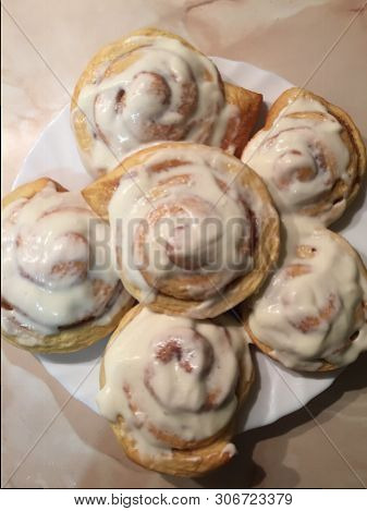 Sinnabon Buns. Cinabon Rolls With Cream Cheese On A White Plate