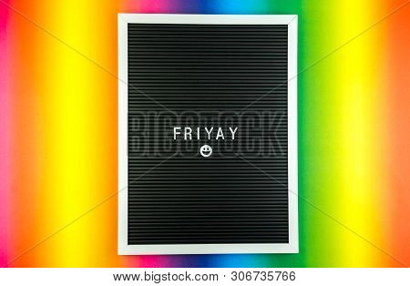 The Word Friday On A Letter Board With Happy Smiley Emoji Against Multicolor Background