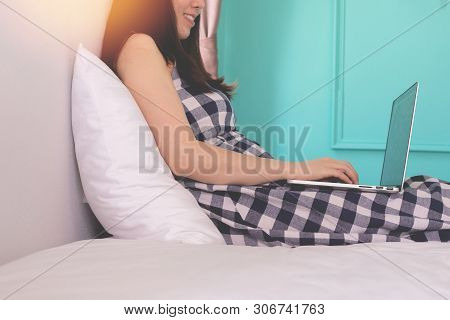 Pregnant Woman Using Laptop On White Bed In Bedroom, Concept Of Find Data, View From Side Woman.