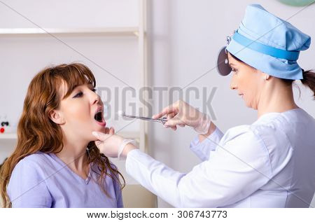 Young woman visiting female doctor otolaryngologist