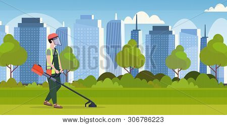 Man Gardener In Uniform Cutting Grass With Brush Cutter Gardening Concept Modern Cityscape Backgroun