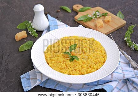 Saffron Risotto In A White Plate On A Dark Concrete Background.