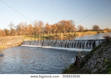 Weir On Olse River In Karvina City In Czech Republic With Trees On The Background During Autumn Day 