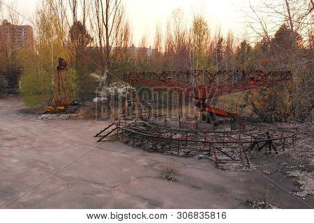 Exclusion Zone Near Chernobyl Nuclear Power Plant. Rusty Carousel In Amusement Park Of The City Of P