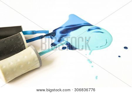 Blue Nail Polish Shellac Varnish Stain With Tassels Dripping Drops Close Up On White Background.