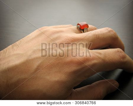 Yemeni Red Akeek Agate Stone. Male Hand With Ring On Ring Finger With Dark Background. Yemen Aqeeq R
