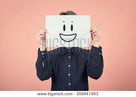 Businesswoman Covering Face Using A White Paper Sheet With Smile Emoticon Sketch, Like Fake Mask For