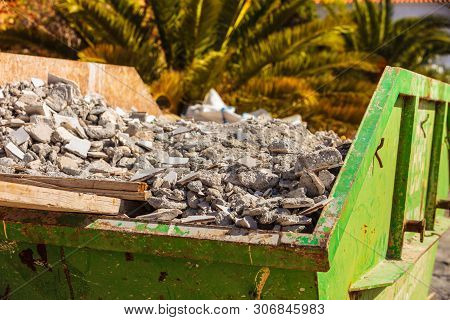 Green Metal Container With Construction Waste Rubble For Disposal. Heavy Garbage On Construction Sit