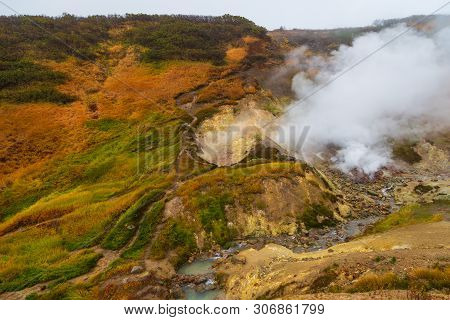 Water Vapor Over The Valley Of Small Geysers. View Of The Eastern Mountain Covered By Clouds, Jelize