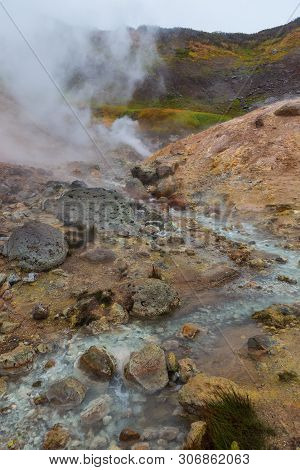 Water Vapor Over The Valley Of Small Geysers. View Of The Eastern Mountain Covered By Clouds, Jelize