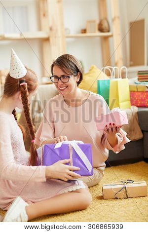 Portrait Of Mother And Daighter Opening Presents At Home Birthday Party, Copy Space
