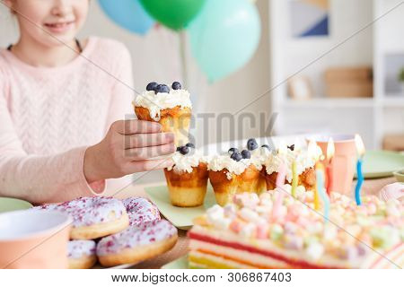 Closeup Of Unrecognizable Litte Girl Holding Homambe Blueberry Cupcake During Kids Party, Copy Space