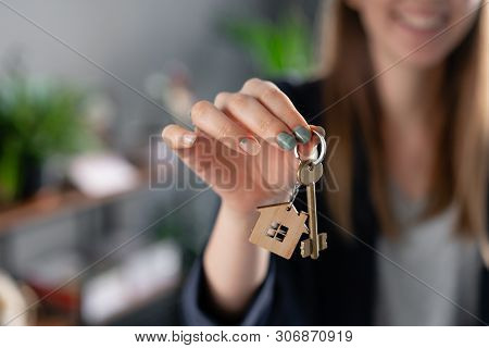 Young Pretty Woman Smiles. House Key In Womans Hands. . Modern Light Lobby Interior. Real Estate, Hy
