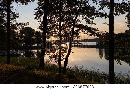 Sunset On The Forest Lake. Beautiful View Of The Biale Lake, Poland In Hot Summer