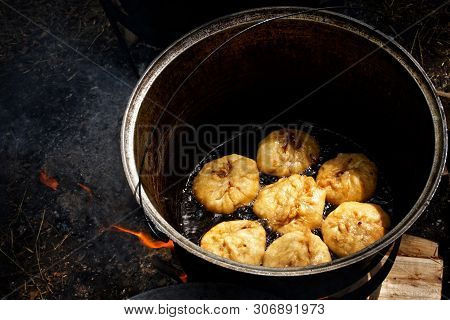 Cooking A National Russian, Bashkir, Tatar Dish - Belyashes In Nature, In A Cauldron On An Open Fire