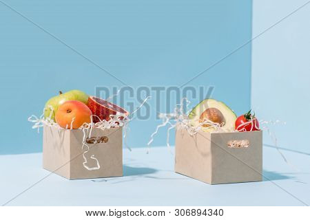 Fresh Vegetables And Fruits Resting In Two Disposable, Compostable Paper Boxes, Filled With Saw Shav