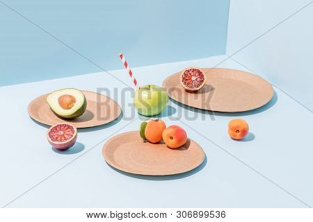Composition Of Fresh Apricots, Cut Avocado And Blood Orange, Apple With Straw Sticking From It On Di