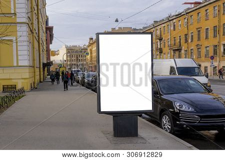 Billboard On The Streets. Street, Cars And Buildings Next To The Bulletin Board. Free Space For Text