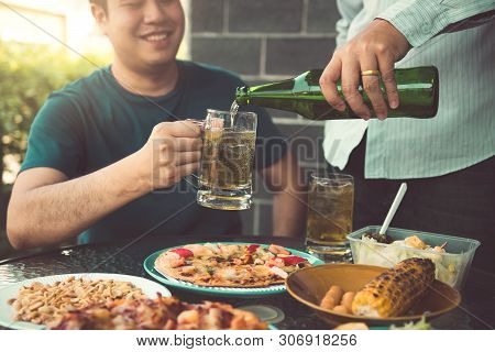Asian Friends Are Helping To Pour Beer Into The Bottle Of His Partner And Have Fun Together In Celeb