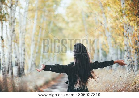 Dreamy Beautiful Girl With Long Natural Black Hair Flies On Bokeh Background Of Autumn Yellow Leaves