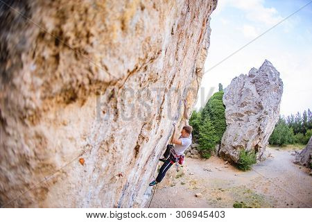 Athletic Man Climbs A Rock, 7c Category Route In The Forest With Rope. Sport Climbing In Crimea, Lea